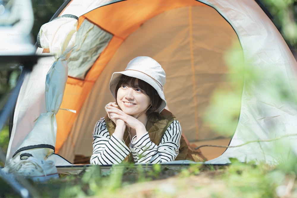 Imagem do acampamento solo - Uma jovem mulher deitada em uma tenda