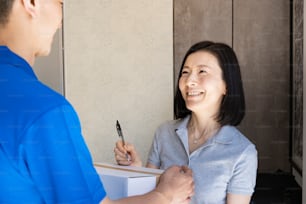 A woman who receives a courier and signs at the entrance