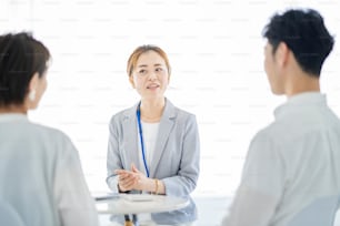 Asian woman in a suit explaining to a couple