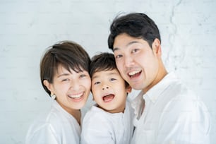 Parents et enfant alignés avec un sourire et un fond blanc texturé