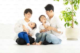 Famille asiatique se relaxant dans une chambre lumineuse
