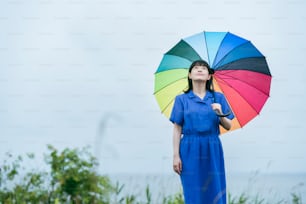 Una donna che tiene un ombrello colorato sotto la pioggia