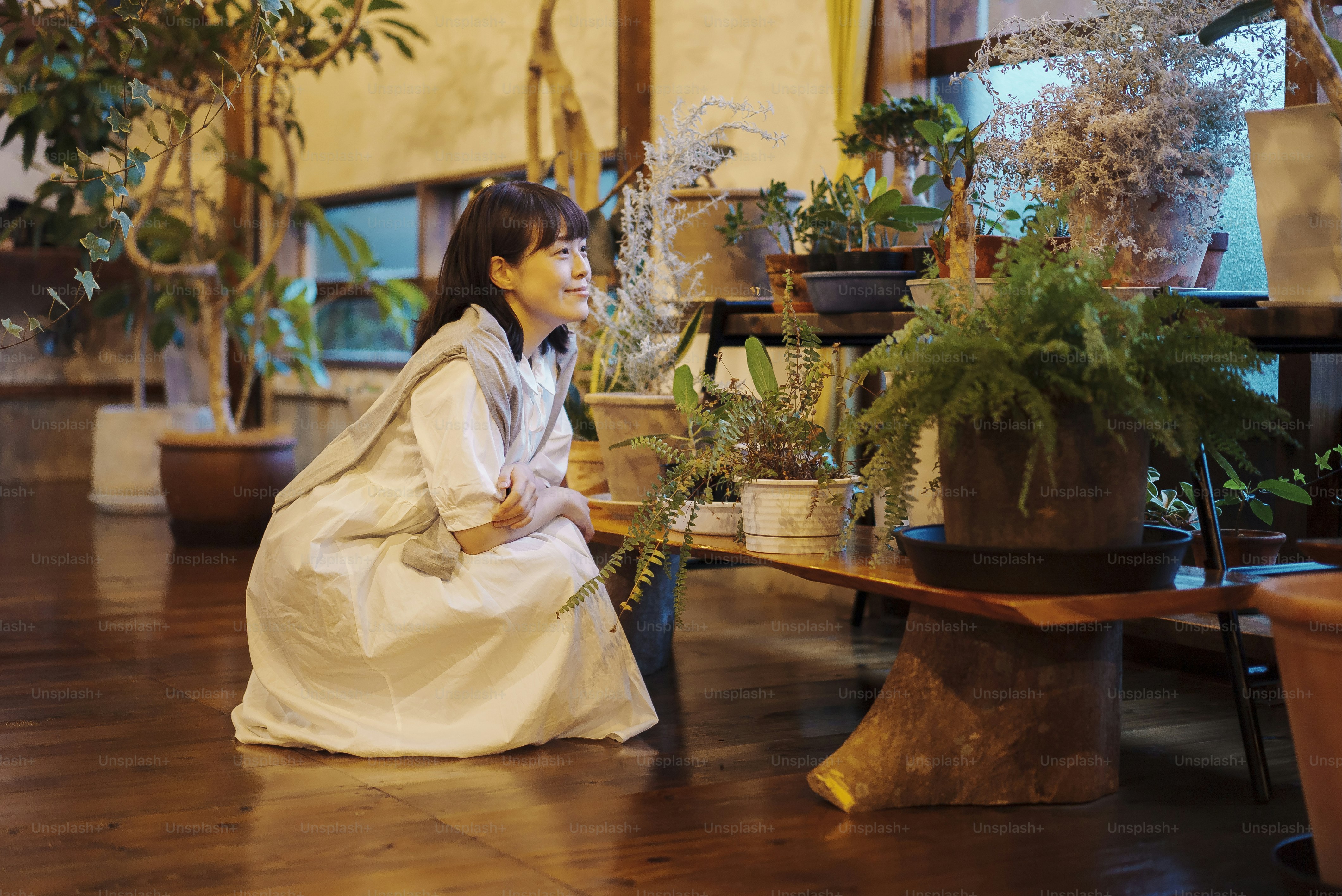 A young woman looking at the foliage plants with a smile