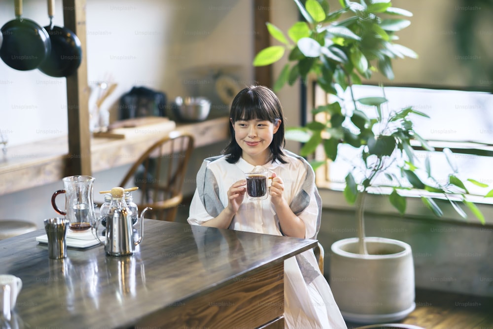 Una joven preparando y bebiendo café en un ambiente tranquilo
