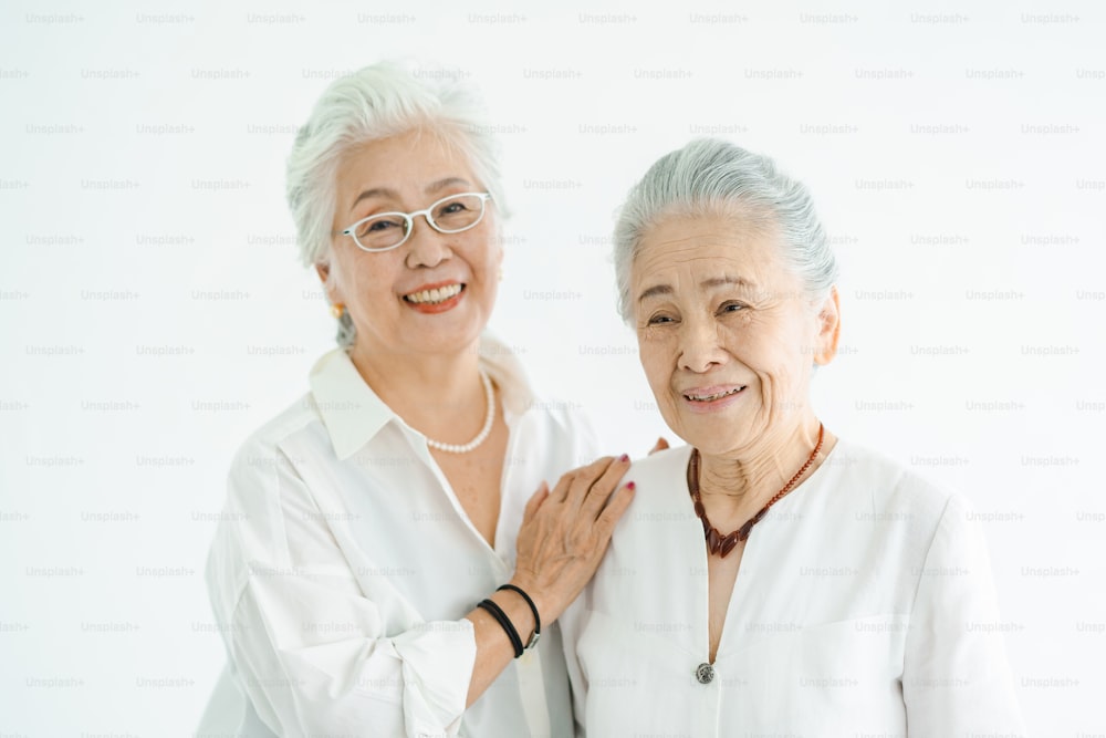 밝은 방에서 미소를 지으며 이야기하는 노년층 여성들