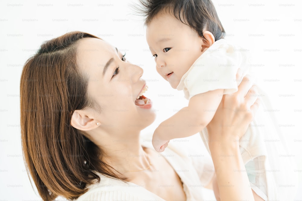Asian mom holding a baby in the bright room