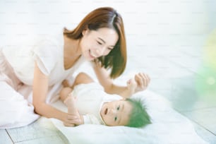 Asian mom and baby playing indoors