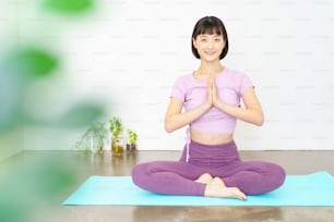 A woman doing yoga poses with her palms together