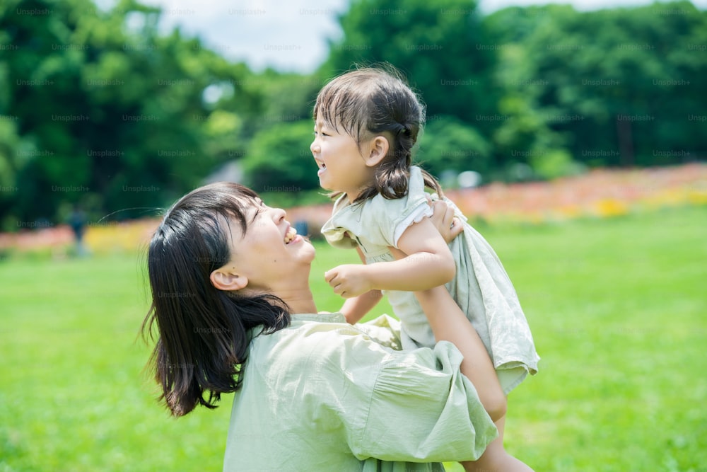 Une jeune mère asiatique et sa fille s’étreignent dans le parc