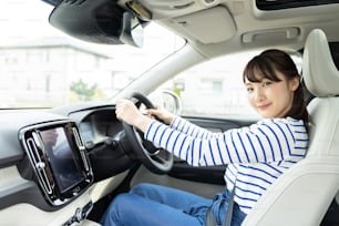 차를 운전하는 젊은 아시아 여성.
