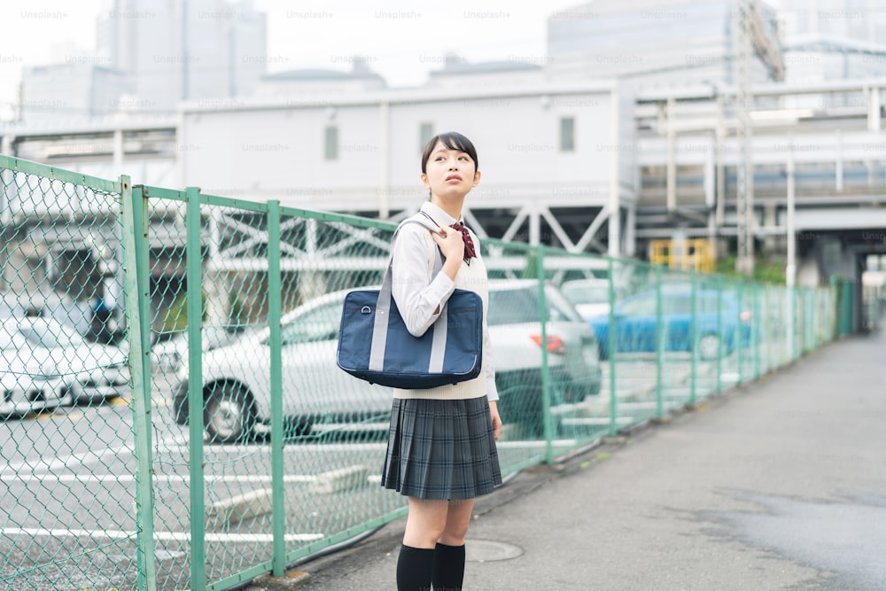 Asian school girl looking up to the sky.