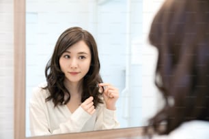 Young asian woman looking a mirror.