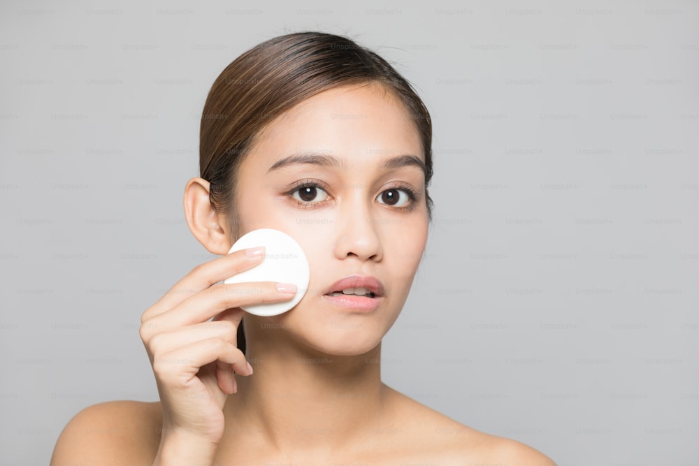 Young woman removing makeup. Skin care concept.