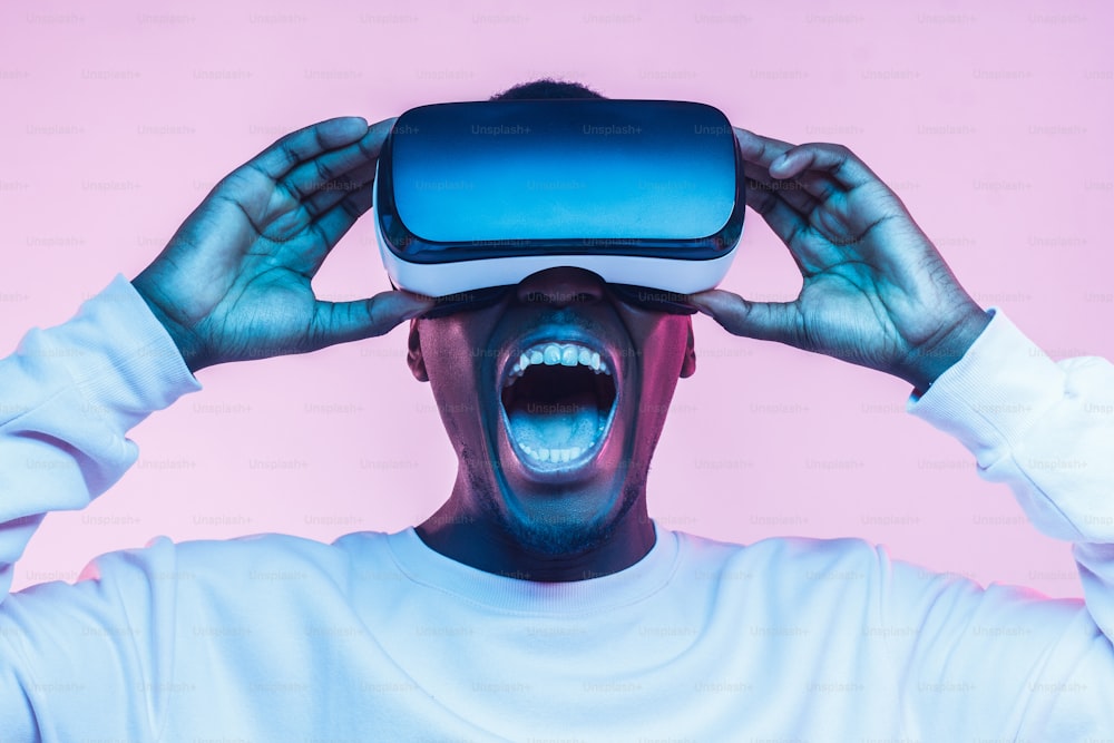 VR 안경을 통해 영화를 보고 있는 흥분한 아프리카 남자가 비명을 지르고 있다