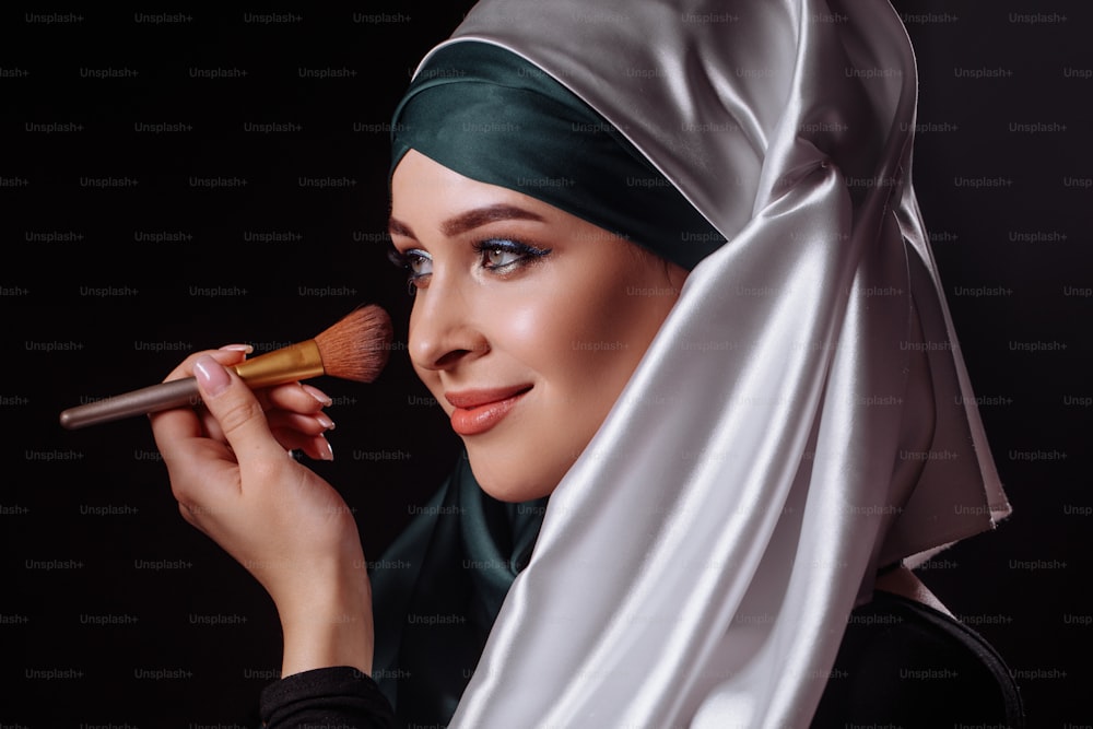 화장을 하고 있는 매력적인 무슬림 여성의 클로즈업 초상화. 얼굴을 마주하다