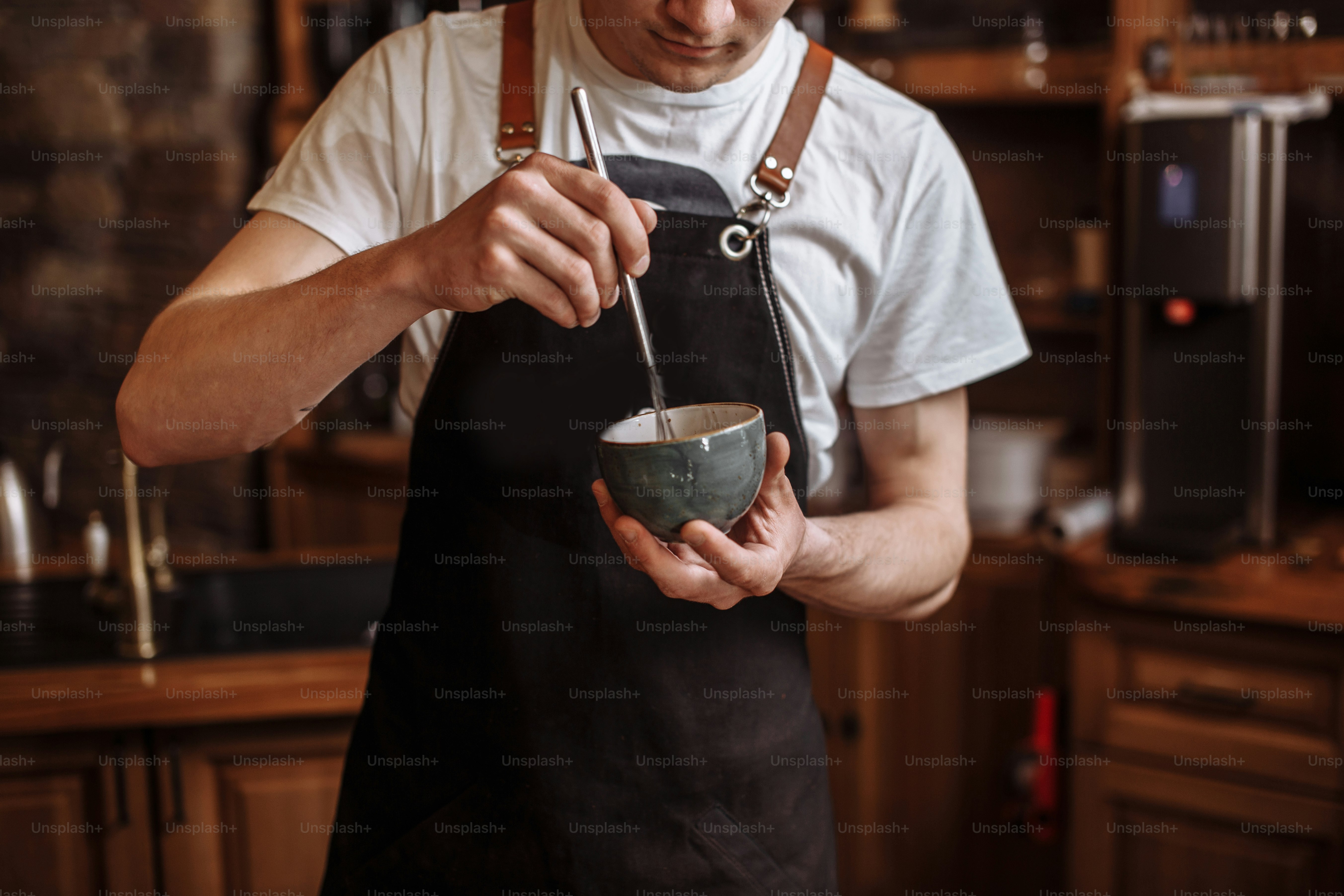 man is making joe in the coffee house.guy is mixing up coffee-ground in the kitchen