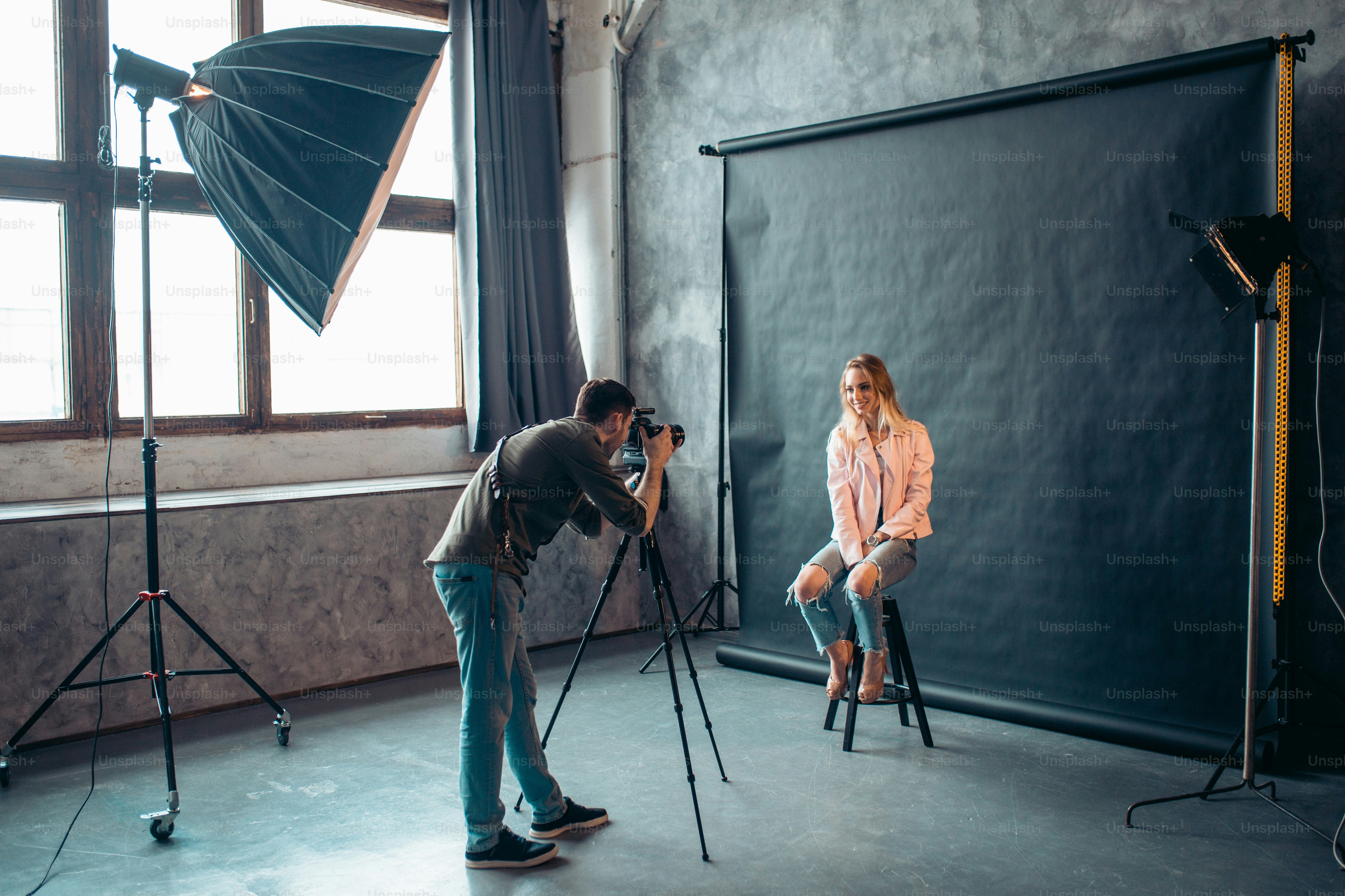 pleasant photographer making a female model laugh, side view full length photo