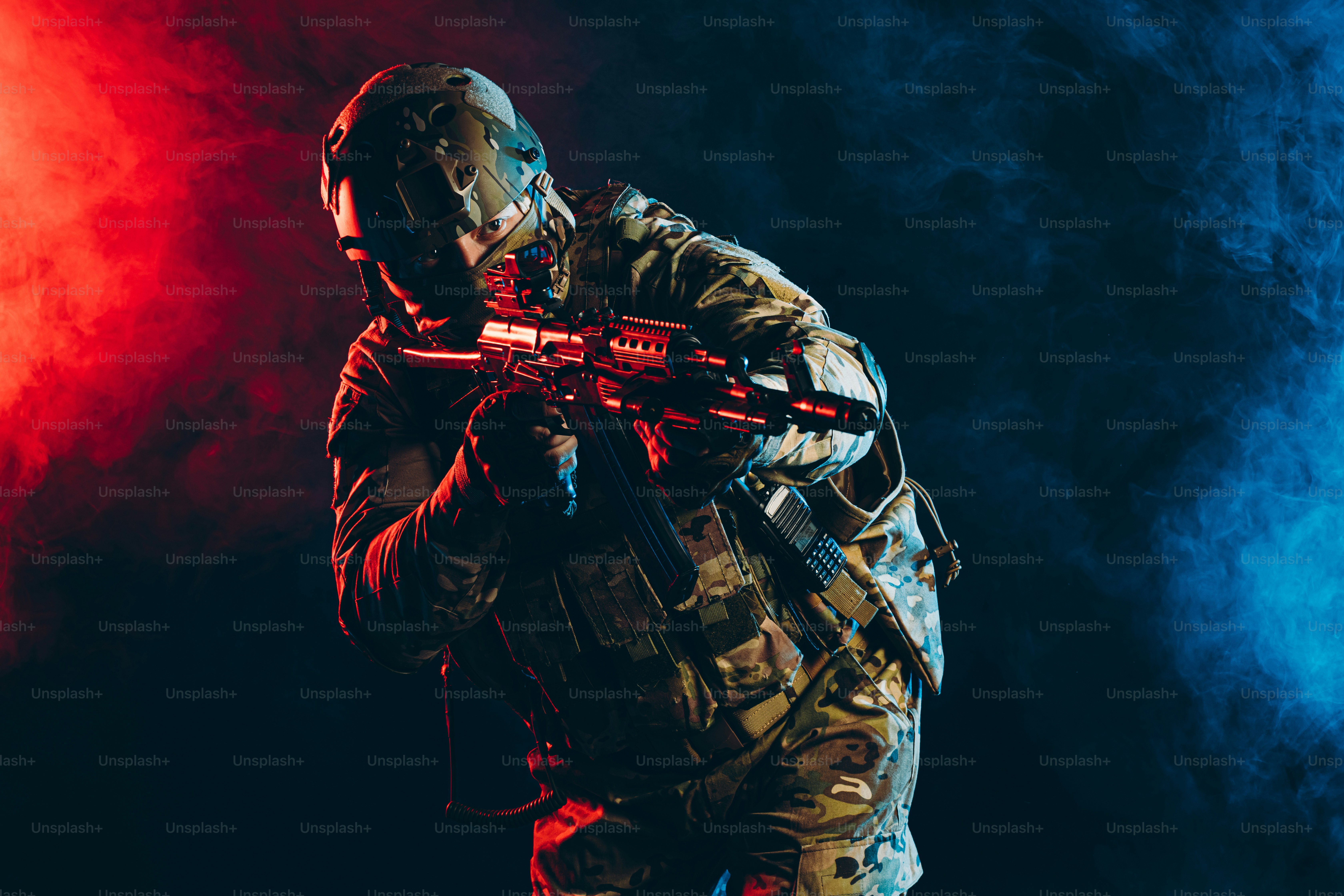 safety and protection concept. young man work as military man protecting country, wearing military forces clothes and holding gun in smoky UV space