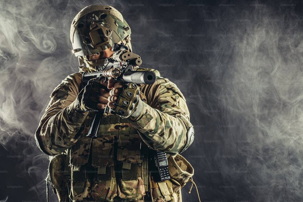 special forces soldier man holding machine gun and military equipment in smoky space