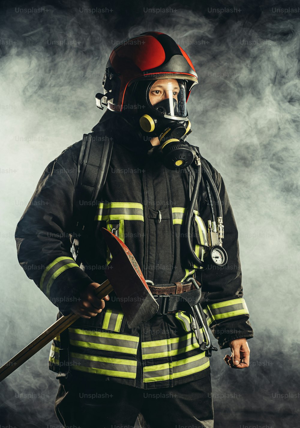 Starker Feuerwehrmann mittleren Alters, der Menschen vor Feuer rettet und schützt, trägt eine spezielle Maske oder einen Helm und eine Schutzuniform