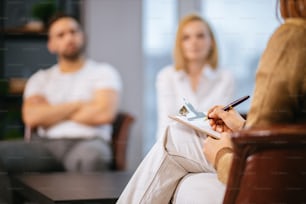 female psychologist taking notes on paper, professional psychologist conducts mental health therapy to young married couple and writing all symptoms of patients, try to help them. therapy, problems, psychology, people relationships concept