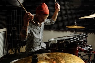 energetic caucasian drummer man professionally play on drums, he enjoy performing music in studio, preparing for concert. rock and roll, music, instruments concept