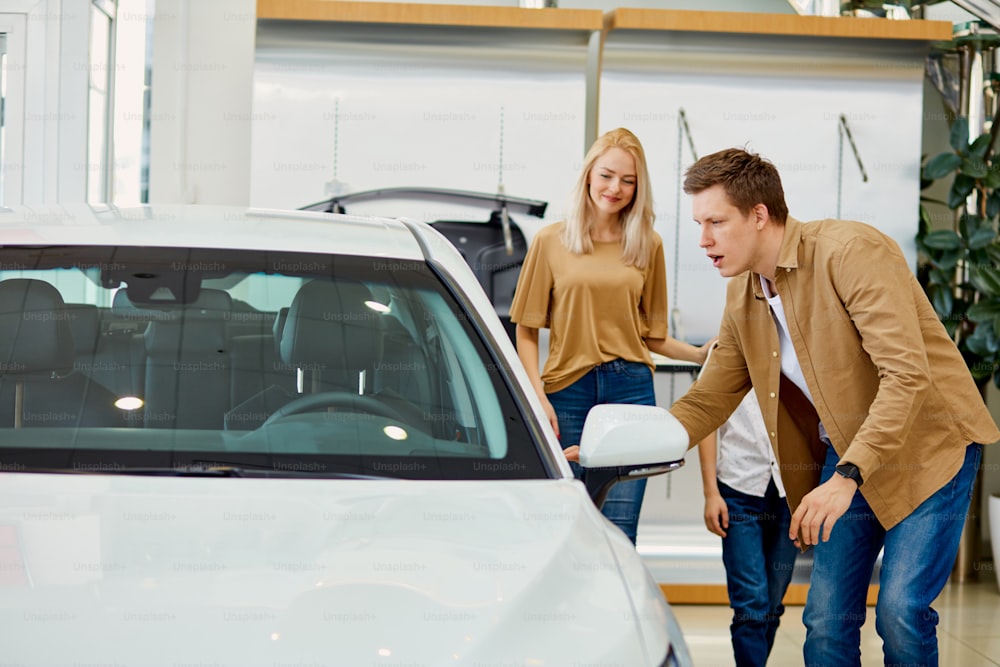 young caucasian family choosing a car in dealership, they want the most comfortable and safe car