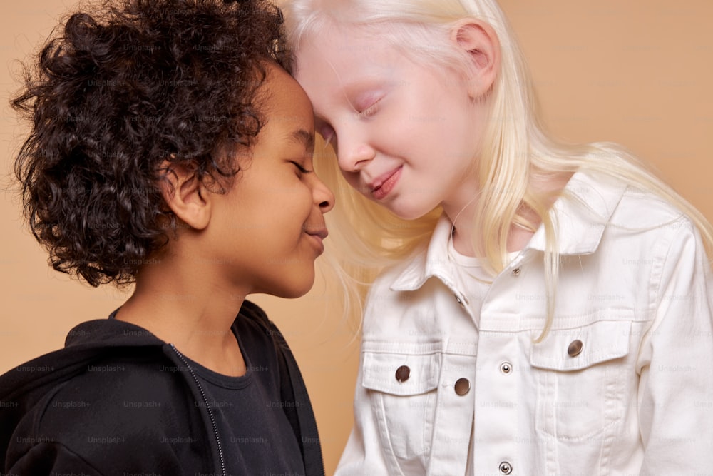 Diversi bambini neri e albini innamorati, hanno sentimenti teneri l'uno per l'altro, persone con capelli e colore della pelle insoliti