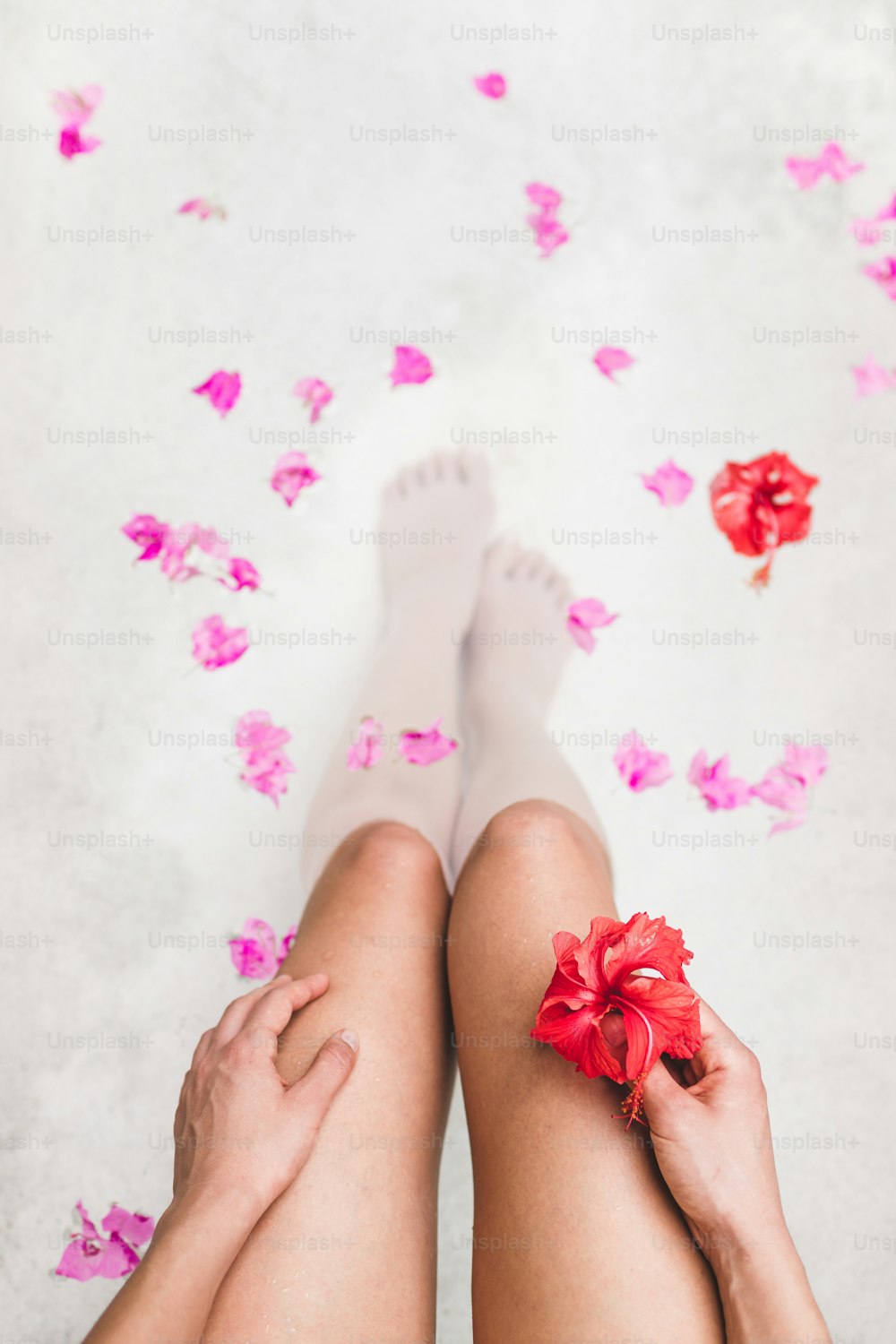 Femme se relaxant dans un bain extérieur rond avec des fleurs tropicales, soins de la peau bio, hôtel spa de luxe, photo de style de vie