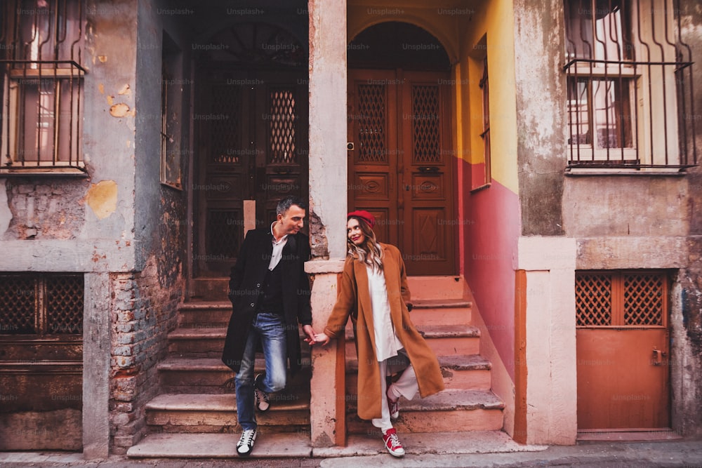 Happy couple in love on the background of old colorful painted facade. Old streets of Istanbul in Balat
