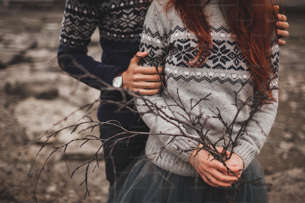 伝統的なアイスランドの秋の外観。女性と男性のカップルに手作りのニットグレーとブルーのセーター。コンセプトブランチブーケ。