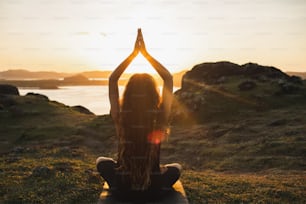 Junge Frau, die Yoga im Freien praktiziert.  Konzept für spirituelle Harmonie, Introspektion und Wohlbefinden. Hintergrund der Landschaft