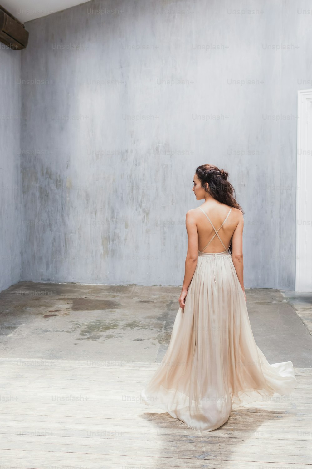 Bride with long black hair in the studio, a photo from the back