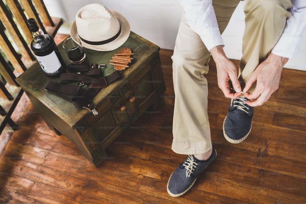 Hombre con zapatos azul de lino ecológico. Novio preparándose