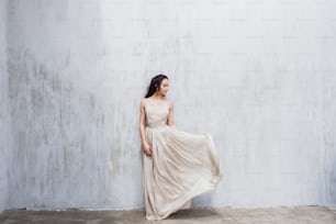 Girl with long black hair in a gentle silk wedding dress