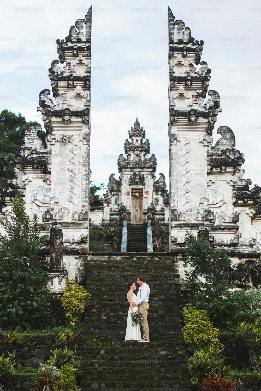 Casal de casamento no templo de Pura Lempuyang em Bali. Famoso marco indonésio, portão balinês tradicional.