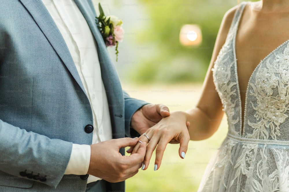 Hombre con anillo de bodas en mano de mujer de cerca. Símbolo de amor y compromiso. Votos de la ceremonia de la boda.