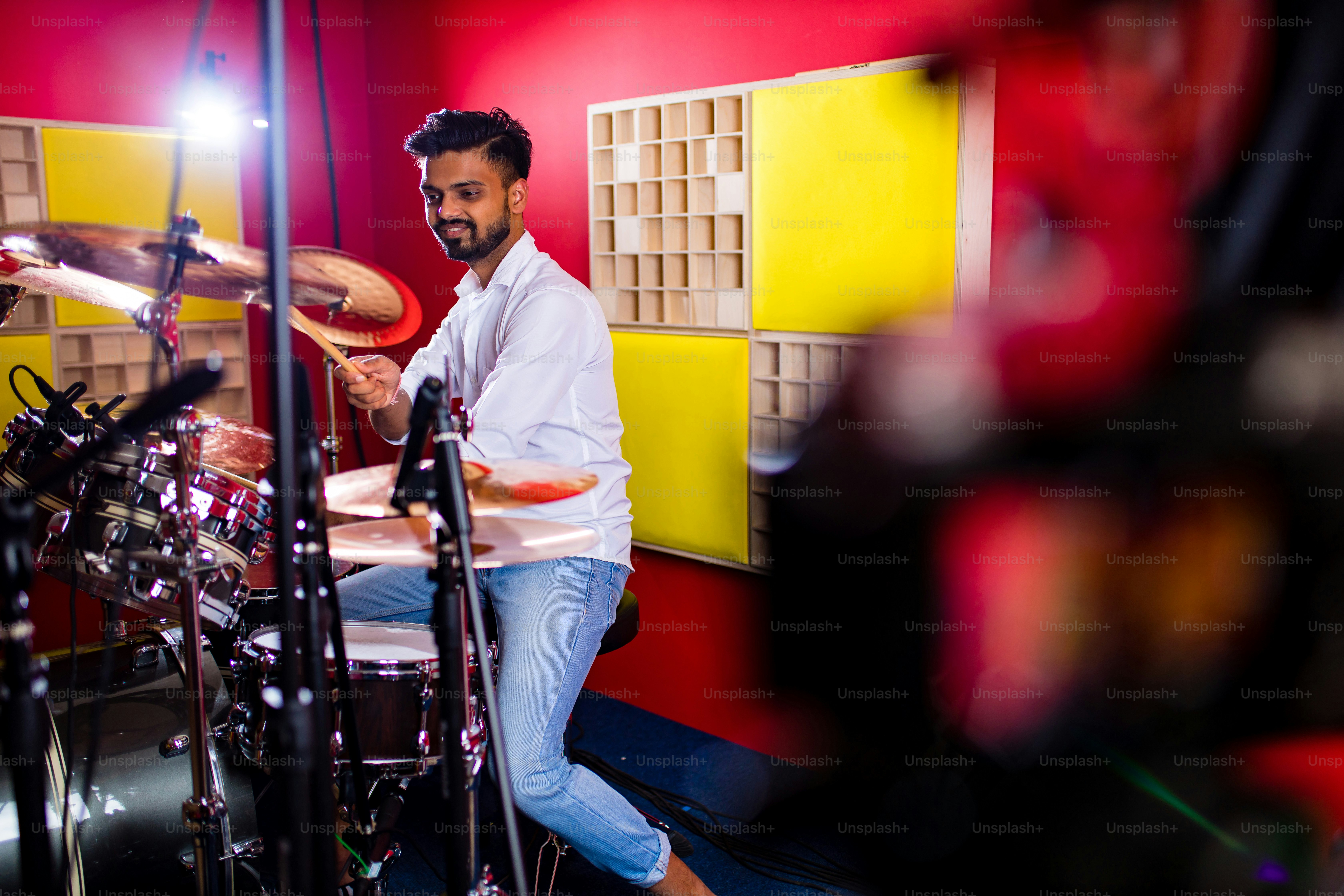 Attractive Teenage Drummer with Drumsticks in recording studio .