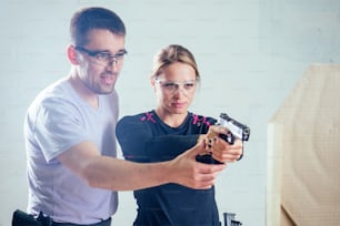 A person target practicing with a handgun for self defense.