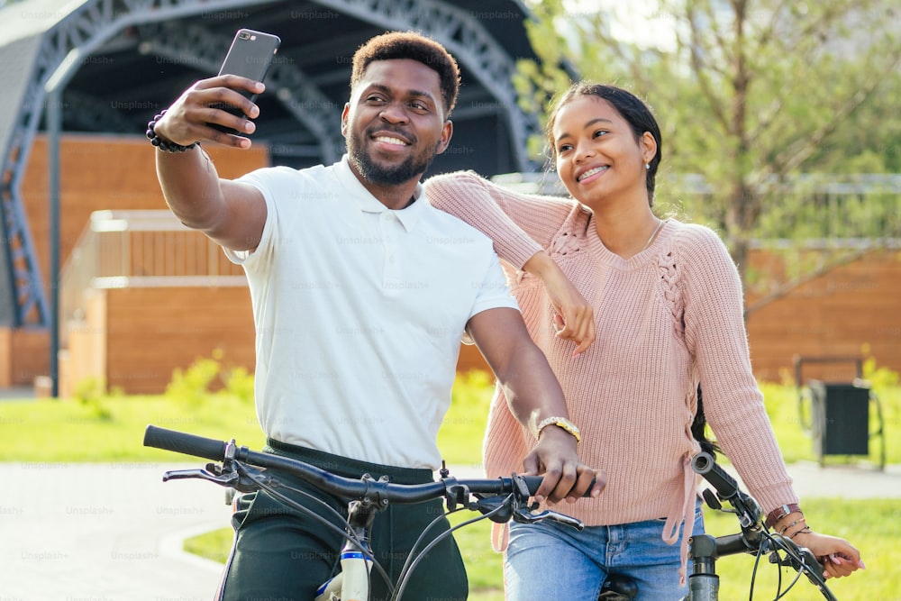 mixed race couple taking a cycle on rent phone app.