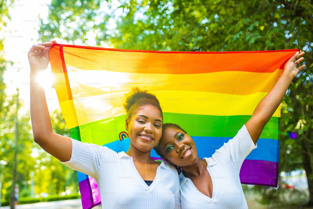 Coppia lesbica brasiliana in abito bianco che trascorre del tempo insieme celebrando il fidanzamento nel parco estivo all'aperto.