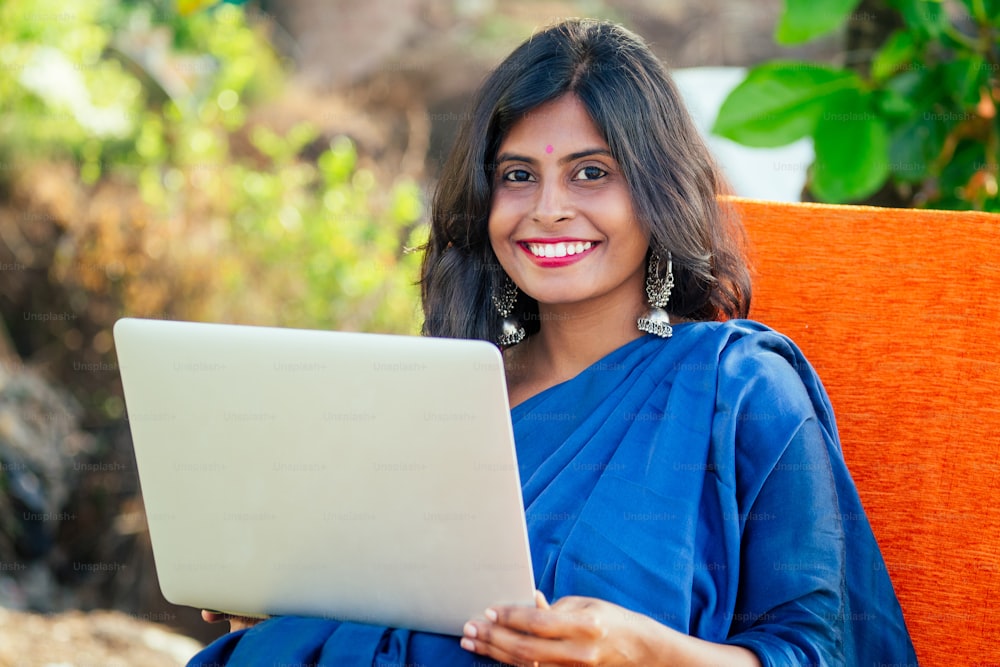 beautiful happy indian woman surfing laptop in tropical resort in Goa business vacation.