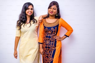 vêtements indiens décontractés, deux femmes indiennes en kurta posant sur un mur blanc.