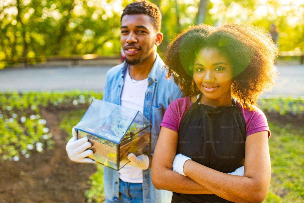 afro american couple gardening outdoors at sunset sunny spring day .