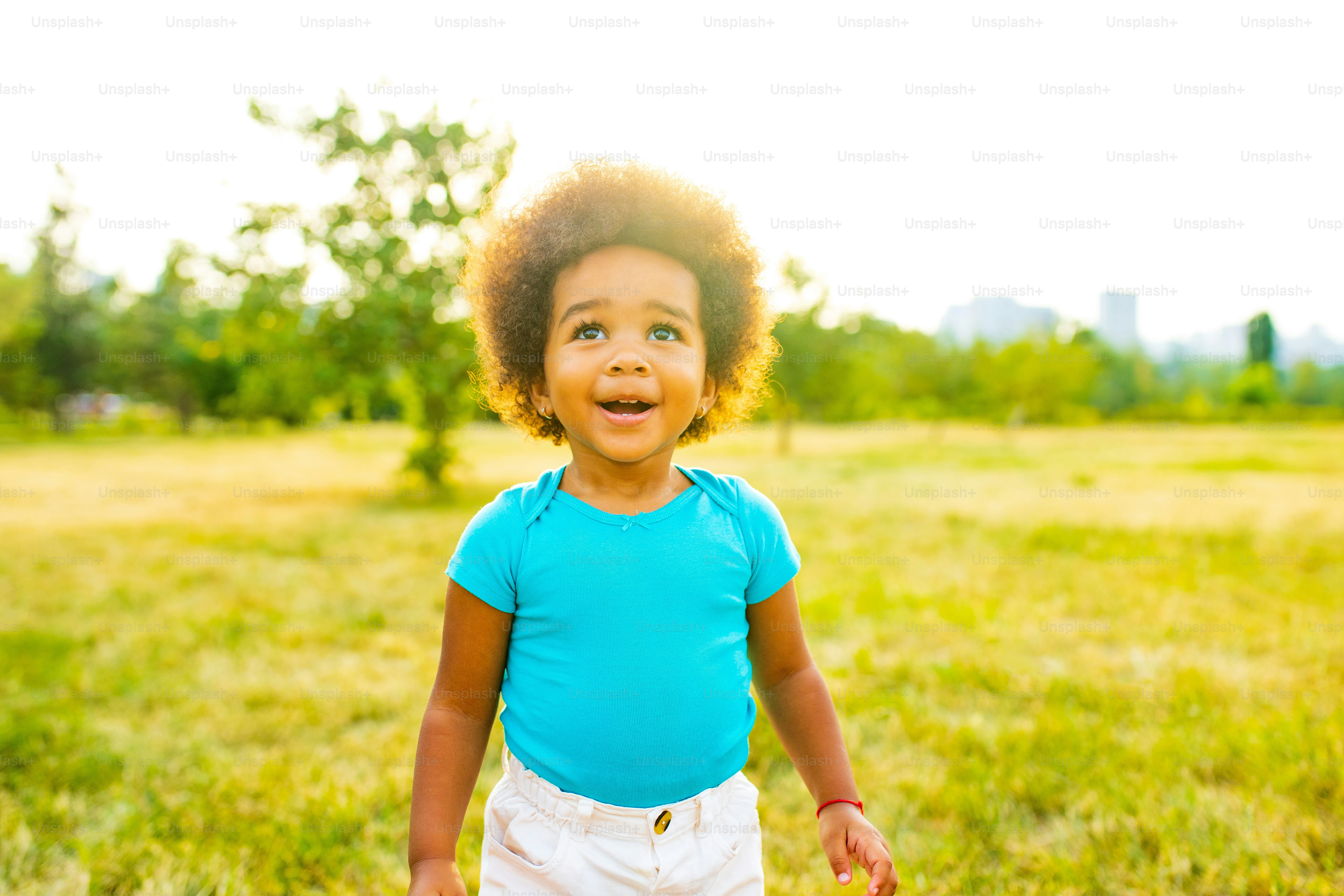 日没時に公園を一人で歩く愛らしい小さな混血の女の子。