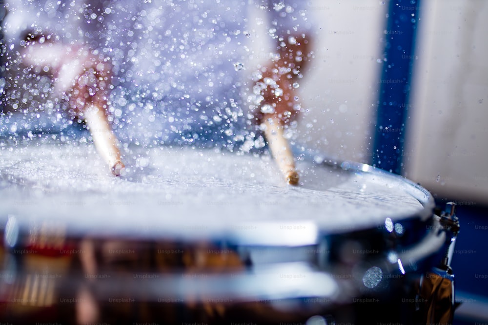 드럼을 연주하는 인도 남자는 녹음 스튜디오에서 클로즈업을 한다.