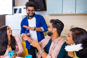 arabian men and women sitting in kitchen and discussing a news.