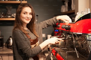 Proprietario del caffè della donna che usa la macchina del caffè