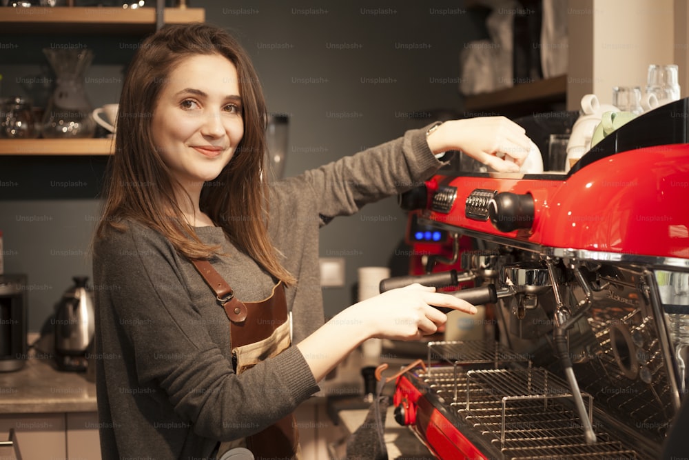 Mujer dueña de una cafetería usando cafetera