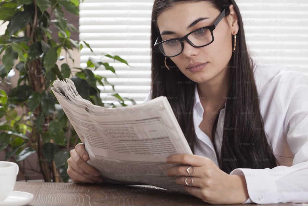 Mujer leyendo periódicos en la oficina
